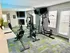 Bright and modern home gym with state-of-the-art equipment, mirrored walls, and natural light streaming through large windows.