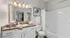 Bright, elegant bathroom featuring a large mirror, sleek countertop, and modern fixtures in a serene setting.