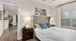 Inviting bedroom with stylish d&eacute;cor, featuring a cozy bed, elegant lamps, and natural light from a large window.