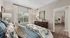 Bright and inviting bedroom with elegant decor, featuring a cozy bed, lush bedding, and large window for ample natural light.