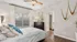 Elegant bedroom with chic decor, featuring a cozy bed with patterned pillows, stylish ceiling fan, and modern dresser, offering a serene and inviting atmosphere.