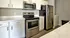 Modern kitchen with sleek stainless steel appliances, white cabinetry, and elegant marble countertops.