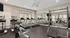 Modern apartment gym with state-of-the-art exercise equipment, including treadmills, ellipticals, and weight machines, all in a bright, mirrored space.