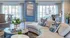 Elegant living room with modern decor, featuring a plush curved sofa, stylish throw pillows, and large windows for ample sunlight.