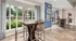 Bright and inviting apartment interior overlooking a serene pool, featuring modern high-top tables and elegant tiling.