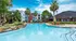 Inviting apartment complex with lush palm trees and a pristine pool, ideal for relaxation and leisure.