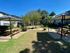 Inviting outdoor common area with picnic tables and lush greenery, perfect for relaxation and social gatherings.