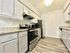 Modern kitchen featuring sleek stainless steel appliances, granite countertops, and elegant white cabinetry.