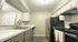 Modern kitchen with sleek appliances, white cabinetry, and elegant countertops in a cozy apartment setting.