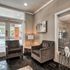 Elegant seating area with plush armchairs and stylish decor, overlooking a refreshing pool through large windows.