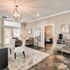 Elegant living area featuring plush seating, chic lighting, and a stylish console adjacent to a sunlit patio.