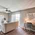 Charming living room with plush seating, cozy work desk, and abundant natural light from sliding glass doors.