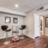 Chic apartment corner with modern bar stools and tasteful wall art, featuring elegant hardwood flooring and a stylish design.