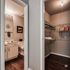 Modern apartment with cozy bathroom featuring elegant decor and an adjoining walk-in closet with ample storage space.