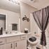 Chic bathroom with modern vanity, stylish lighting, and playful bicycle wall decor, perfect for a cozy apartment.