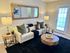 Elegant living room with contemporary decor featuring a plush cream sofa, chic wooden tables, and a stylish wall mirror, creating a warm and inviting atmosphere.