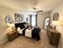 Elegant bedroom featuring a comfortable bed with plush pillows, stylish wall art, and chic lighting in a cozy setting.