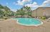 Charming residential swimming pool with a tranquil setting, surrounded by lush trees and comfortable lounge chairs, perfect for relaxation and leisure.
