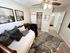 Charming bedroom with cozy daybed, plush pillows, and stylish decor, featuring modern artwork and a chic animal print rug.