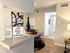 Inviting apartment interior with elegant decor, featuring a chic countertop display of wine and grapes, modern art, and a sign reading 'New Home, New Memories.'