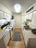 Charming white kitchen with sleek countertops, modern appliances, and stylish decor, featuring a cozy rug and inviting lighting.