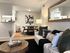 Inviting apartment interior showcasing a cozy living area with elegant decor, modern dining setup, and open kitchen design.
