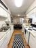 Charming kitchen with sleek white cabinetry, modern appliances, and cozy dining area, perfect for stylish living.