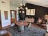Chic living and dining area with modern chandelier, stylish furniture, and warm wooden accents, offering a cozy, inviting atmosphere.