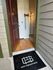 Inviting apartment entrance with warm wood flooring and elegant modern lighting, showcasing a welcoming atmosphere.