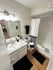 Modern bathroom featuring elegant fixtures, a sleek vanity with storage, and a stylish shower-tub combination, accented by chic black and white decor.