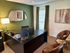 Chic home office with modern desk, stylish leather chairs, and artistic decor, perfect for productivity.