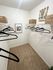 Spacious walk-in closet with sleek black hangers, integrated shelving, and stylish decor for a modern touch.
