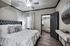 Elegant bedroom featuring a plush bed with tufted headboard, stylish decor, and access to a spacious walk-in closet.
