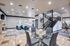 Luxurious open-concept living room with elegant staircase, cozy fireplace, and stylish dining area, showcasing modern decor and ample natural light.