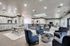 Luxurious open-concept communal area with plush seating, a stylish glass coffee table, elegant lighting, and a modern kitchen with a bar counter.