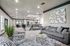 Elegant open-concept living area with plush gray sofas, modern geometric armchairs, and chic decor in a spacious apartment.