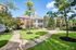 Charming apartment complex with lush greenery, well-maintained paths, and inviting outdoor spaces.