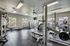 Spacious fitness center equipped with modern exercise machines, free weights, and large windows for natural light.