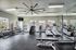 Modern fitness center with large windows, featuring treadmills, weights, and exercise equipment in a bright and inviting space.