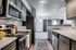 Modern kitchen in open-concept apartment with stainless steel appliances, elegant cabinetry, and sleek countertops.