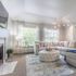 Bright and inviting living room with plush sectional sofa, modern decor, and ample natural light from large windows.