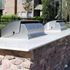 Modern outdoor barbecue grills on a stylish stone countertop, enhancing the communal living experience in a charming residential setting.