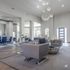 Elegant modern living space with plush gray seating, chic lighting fixtures, and natural light pouring through large windows.