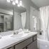Elegant bathroom with a modern sink, polished countertops, and a clean, bright ambiance; featuring stylish fixtures and pristine white towels.