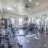 Modern fitness center with state-of-the-art equipment, including treadmills, weights, and stability balls, in a bright and spacious room.