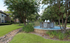 Charming apartment complex garden with a serene fountain surrounded by lush greenery and beautiful trees.