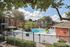 Beautiful apartment community with a sparkling pool, lush landscaping, and modern outdoor seating, offering a resort-style living experience.