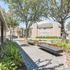 Charming community courtyard with lush greenery, modern benches, and vibrant flower beds, providing a serene outdoor escape.