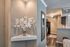 Modern apartment with elegant corner shelf displaying a white decorative plant, leading to a sleek kitchen with granite countertops and dark cabinetry.
