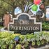 Inviting entrance sign for The Farrington, featuring vibrant balloons and lush landscaping under shady trees.